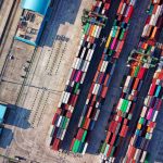 Top view of colorful shipping containers at a bustling port in Jakarta, Indonesia.