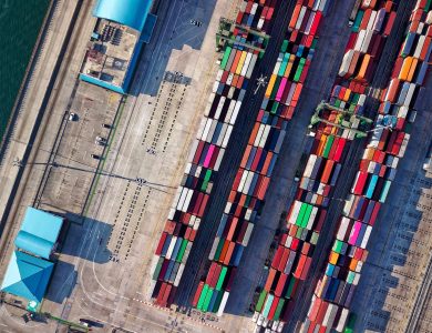 Top view of colorful shipping containers at a bustling port in Jakarta, Indonesia.