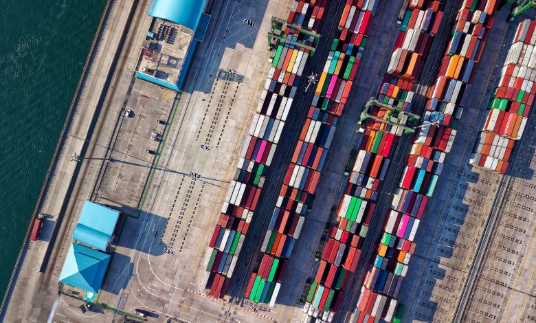 Top view of colorful shipping containers at a bustling port in Jakarta, Indonesia.