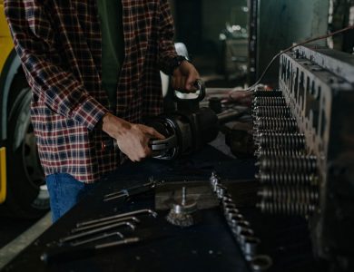 Mechanic using tools in an auto repair workshop for vehicle maintenance.