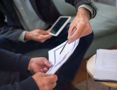 Close-up of two business professionals discussing documents in a meeting.
