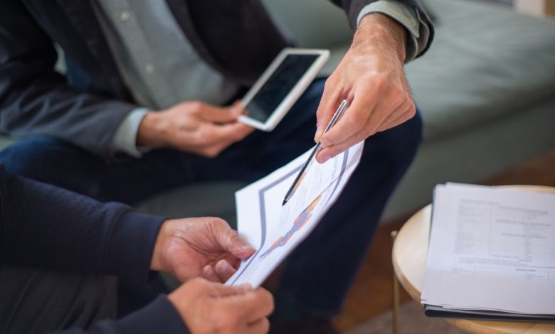 Close-up of two business professionals discussing documents in a meeting.